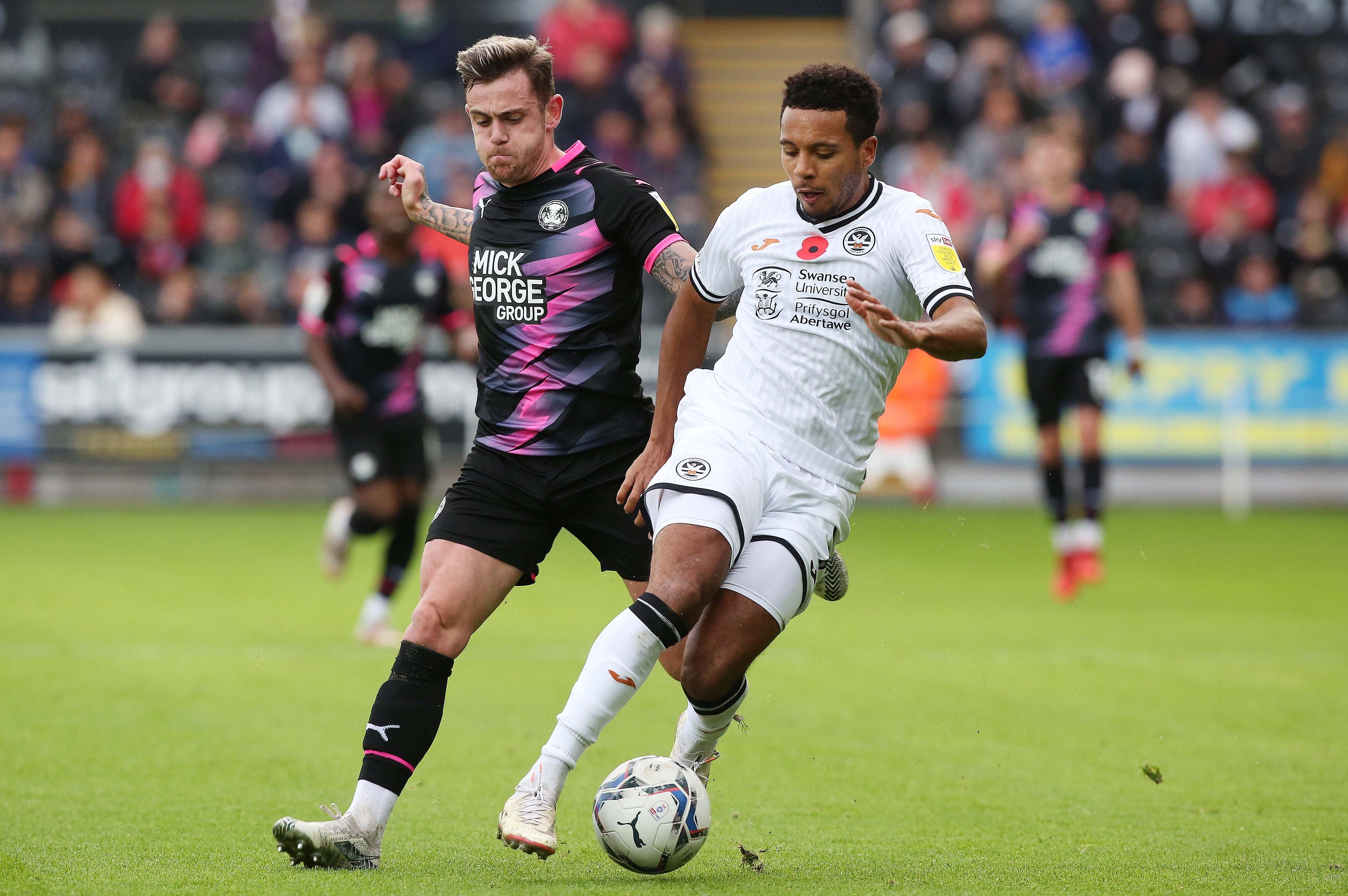 Sammie Szmodics of Peterborough United in action with Korey Smith of Swansea City. Photo: Joe Dent/theposh.com