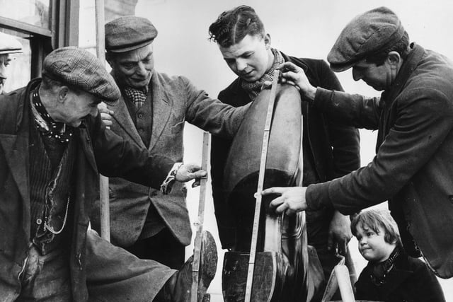 12th March 1937: Roadmen inspect a giant boot made especially made for Northampton Football Club. (Photo by Ward/Fox Photos/Getty Images)