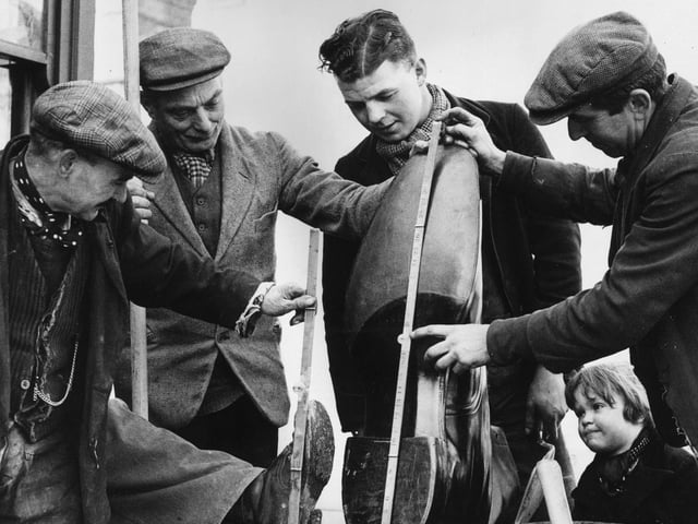 12th March 1937: Roadmen inspect a giant boot made especially made for Northampton Football Club. (Photo by Ward/Fox Photos/Getty Images)