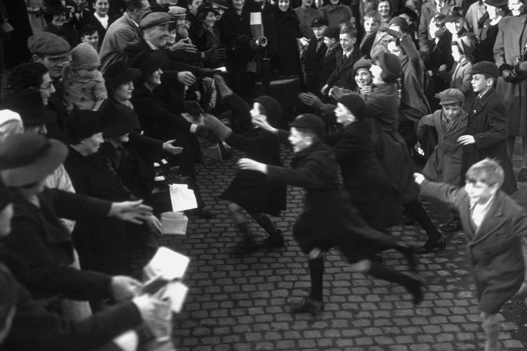 3rd December 1939: Happy evacuee children rush to greet their parents off the special London Midland and Scottish train in Northampton. (Photo by J. A. Hampton/Topical Press Agency/Getty Images)