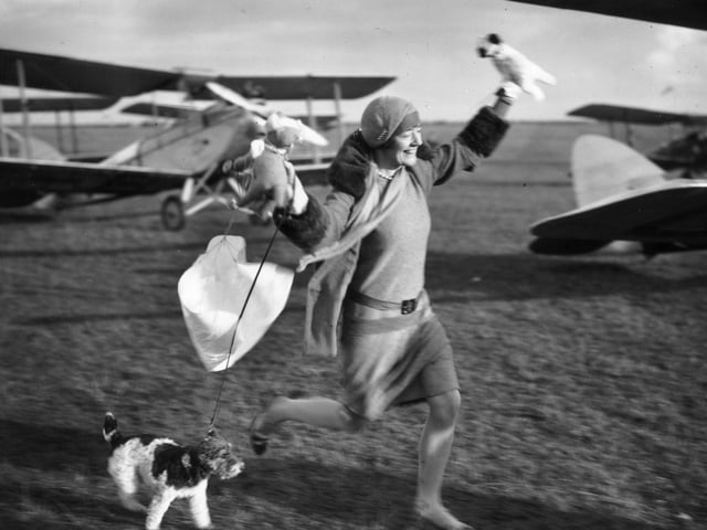 November 1929: The Honourable Mrs Chesterman retrieves the toy animals dropped by a parachute at a Northampton Aero Club meet. (Photo by Puttnam /Topical Press Agency/Getty Images)