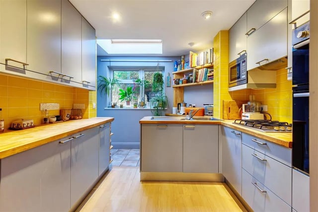 The kitchen is fitted with built-in appliances and has a skylight window to bring in more natural light