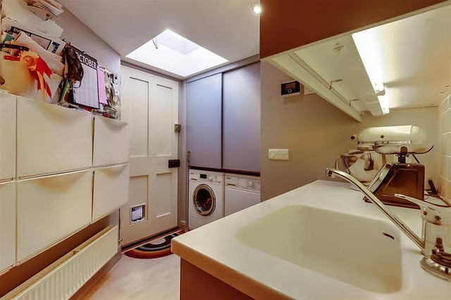 The large utility room is fitted with storage and an additional sink and leads to an enclosed courtyard area to the side