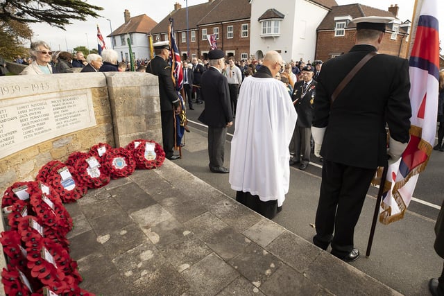 The Rev. Andrew Wilkes MA leads the Remembrance Service standing between Standard Bearers, a large crowd gathered as the High Street was closed during the Service. Wreaths laid by Armed Forces, Police, Life Boat, Royal British Legion, Scouts and Guides and school students.
