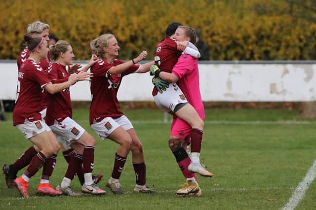 Izzy McDonald is mobbed by her team-mates after saving the vital penalty. Pictures: Pete Norton.