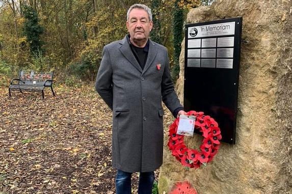 The memorial glade in Woodford Halse with a committee member. The stone has names of veterans and deceased railway workers to remember them.