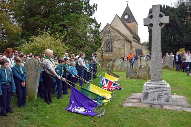The 2nd Ifield Scout Group lower the colours during the two minutes silence at the war memorial at St Margaret's Parish Church. Picture by Scott Wheeler