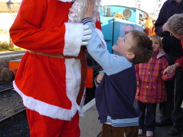 Santa arriving at NVR wansford has his beard tugged by Sonny Hollingsmith, 6