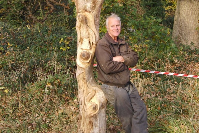Wood carver Graham Jones next to his creation in Priory Park. Photo by Geoff Ousbey