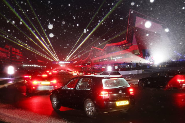 Snowflakes danced in the lights as cars hit the track