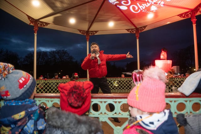 Local entertainer David Harrop leads Christmas songs around the bandstand in the Pump Room Gardens, at the 2021 Leamington Lantern Parade.
