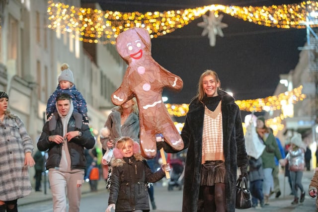 A family with a gingerbread man lantern enjoying the 2021 Leamington Lantern Parade.