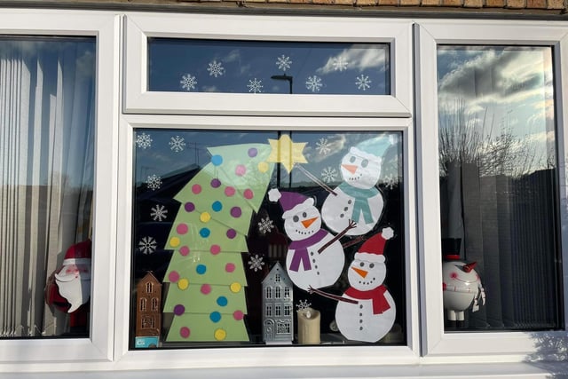 Window number 4 shows the snowmen coming together to help build the Christmas tree.