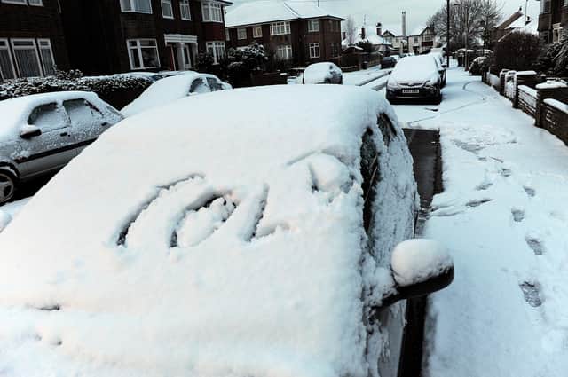 The early morning scene in Dawes Avenue, East Worthing, on December 18, 2009, as a motorist made a comical start on clearing his car of snow. Picture: Stephen Goodger W51041H9