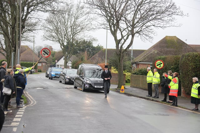 Scores of people lined the street to pay tribute to Worthing lollipop man Terry Rickards as his funeral cortege drove past the spot where he served