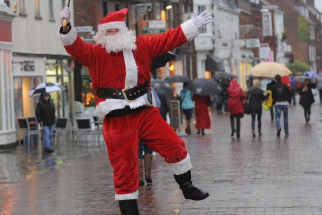 Joyful Santa dancing in the street to mark the beginning of festive shopping in Chichester in 2012. Picture: Louise Adams C121613-2
