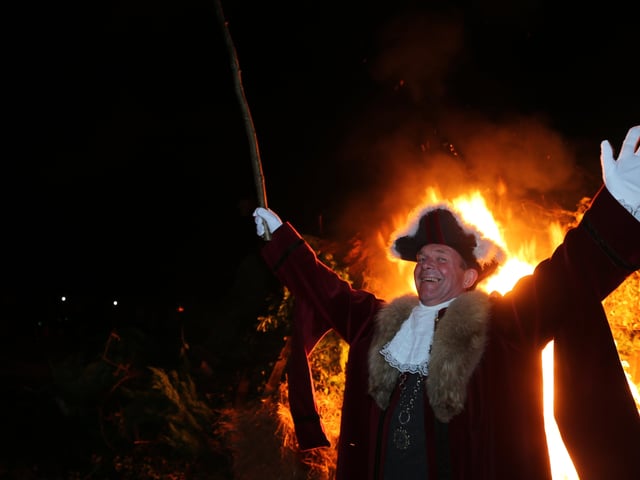 Cuckfield Mayor Andy Leask celebrating the traditional lighting of the bonfire at Cuckfield Bonfire 2021. SUS-210811-160938001