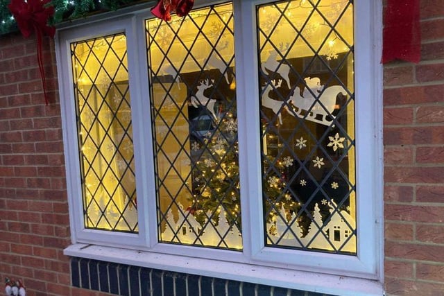 Santa's sleigh is flying through the sky in this festive window