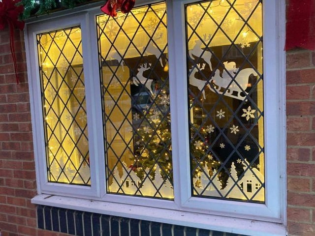 Santa's sleigh is flying through the sky in this festive window