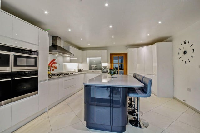 From the dining area there is a glazed internal door to the modern fitted kitchen which is fitted with an extensive range of white gloss fronted units with quartz work surfaces above.