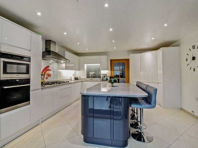 From the dining area there is a glazed internal door to the modern fitted kitchen which is fitted with an extensive range of white gloss fronted units with quartz work surfaces above.