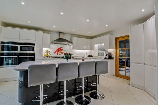 From the dining area there is a glazed internal door to the modern fitted kitchen which is fitted with an extensive range of white gloss fronted units with quartz work surfaces above.