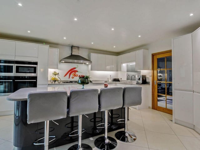 From the dining area there is a glazed internal door to the modern fitted kitchen which is fitted with an extensive range of white gloss fronted units with quartz work surfaces above.