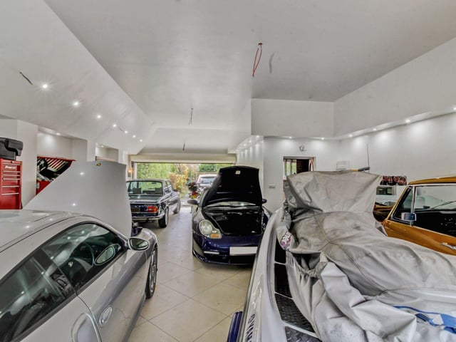 Outside there is an attached garage which is large enough to be a fantastic workshop for any car and/or bike enthusiast, as it comfortably has space for 5-6 vehicles with electric double width doors to both the front and rear.