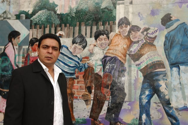 Faded crumbling mural on the corner of Gladstone Street/Link Road P'boro. Kursheed Ahmed (31) who is pictured in the mural is calling for it to be restored. 
In the group of four boys, childhood friends, he is second from left so (l-R) Gul, Kurhseed, Waheed and Khalid