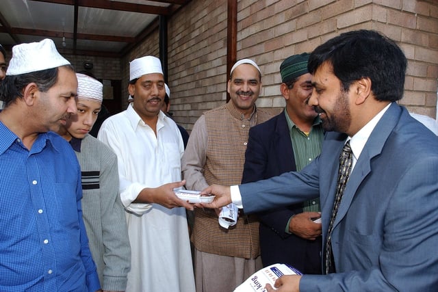 Ghulam Shabbir [blue suit] handing out leaflets and dates  to members of the Gladstone Street mosque at 406 Gladstone street - as part of an anti-smoking campaign.