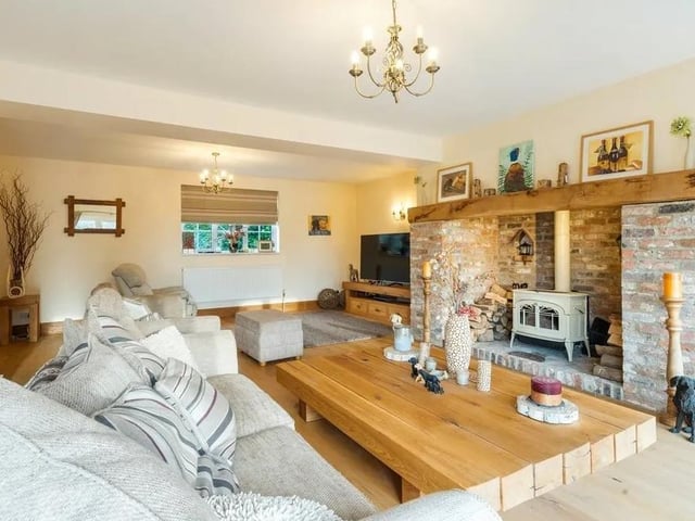 The large drawing room features a brick inglenook fireplace with a woodburning stove Picture: Savills - Haywards Heath.