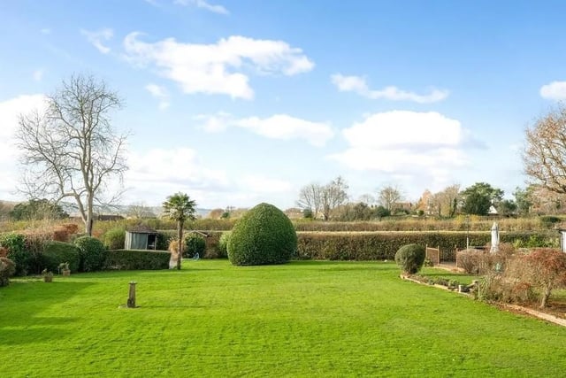 The garden is predominantly laid to lawn and is bounded by beech hedging with far reaching views to the South Downs. Picture: Savills - Haywards Heath.