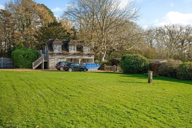 Middle Lodge is a chalet-style detached house with rendered elevations under a tiled roof with large window gables. Picture: Savills - Haywards Heath.