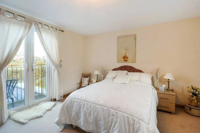 The guest bedroom has an en suite bathroom and French doors opening to a balcony. Picture: Savills - Haywards Heath.