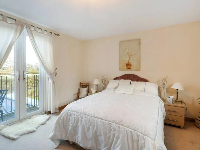 The guest bedroom has an en suite bathroom and French doors opening to a balcony. Picture: Savills - Haywards Heath.