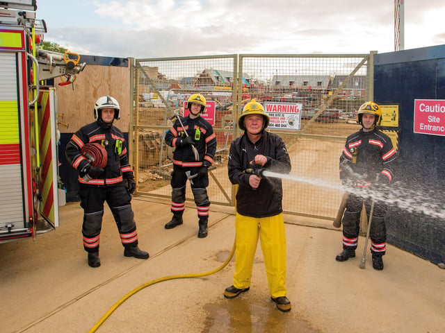 John  wore his original helmet for the reunion photo, but his yellow plastic trousers were changed as they had melted. He was joined by his former colleagues for the reunion (from left) Watch Commander Steve Peacock, firefighter Rob Woodcock and firefighter Tom Bishop.