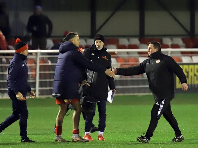 Kettering manager Paul Cox shakes hands with former Poppies striker Tre Mitford at the final whistle