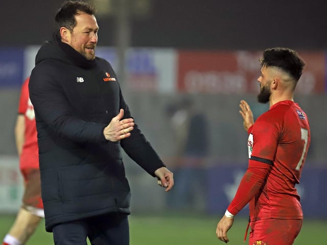 Goalkeeper coach Shaun Allen congratulates two-goal Callum Powell after the final whistle