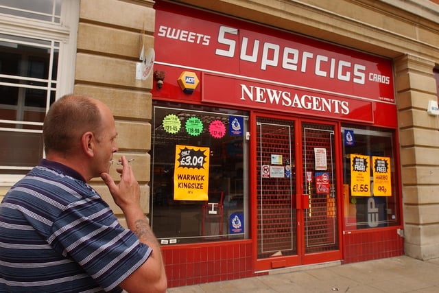 Supercigs at Bridge Street - closed, a passing smoker looks on.