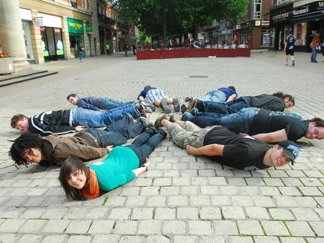 The Laying Down game - A group of friends were attempting a public performance stunt by lying down in the middle of Bridge Street, part of a craze that was sweeping the world.