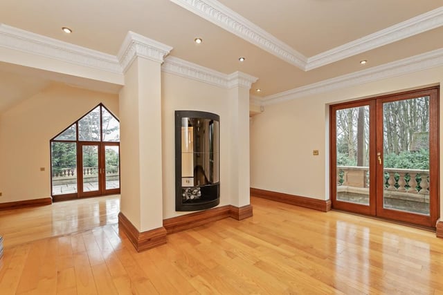 The impressive lounge has a bay window to front, wooden flooring, two double doors to side, open access either side of fireplace with steps down to family room