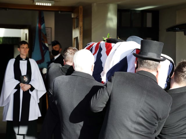 Rev Tom Houston receives Reg's coffin into the chapel
