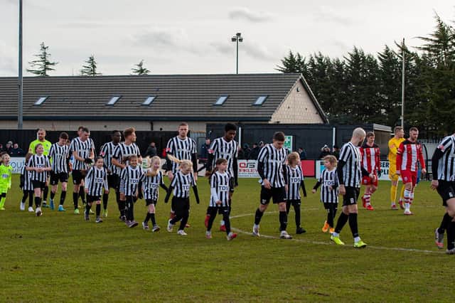 The Corby Town players enter the pitch ahead of the game