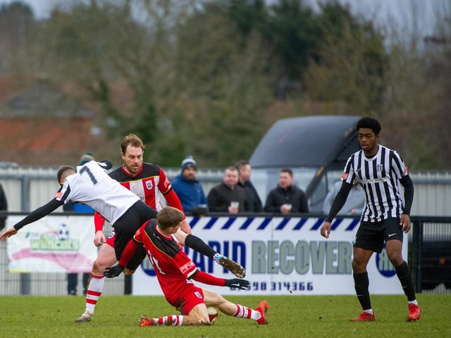 Connor Furey is on the end of a heavy challenge from an Ilkeston opponent
