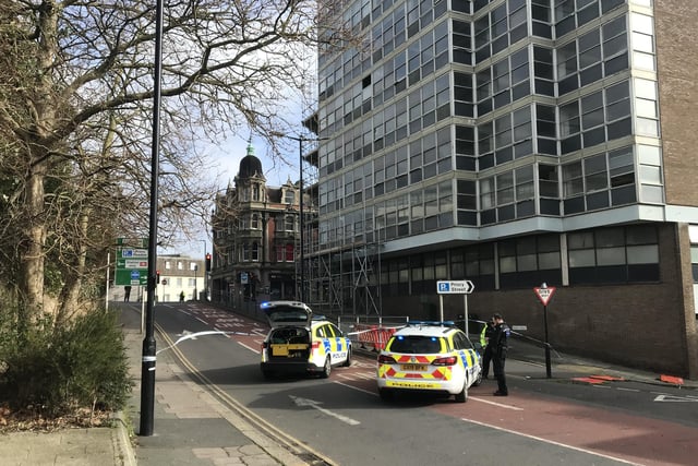 Police close off an area of Hastings town centre after scaffolding boards fall off building SUS-220218-150124001