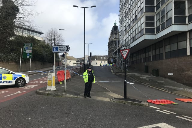 Police close off an area of Hastings town centre after scaffolding boards fall off building SUS-220218-150135001