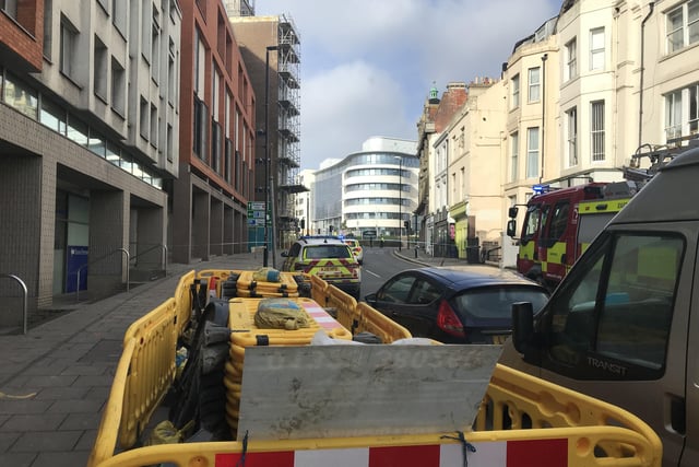 Police close off an area of Hastings town centre after scaffolding boards fall off building SUS-220218-150049001