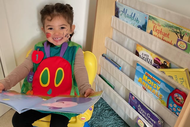 Eliza Sembie-Ferris, aged two, enjoying reading a book dressed as the Hungry Caterpillar before school this morning.