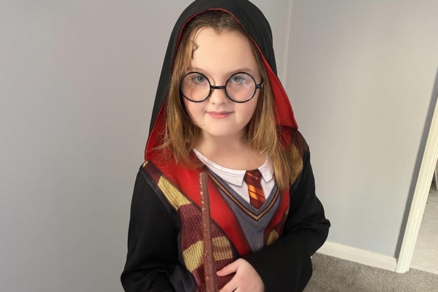 Millie casting a spell dressed as Harry Potter for World Book Day.