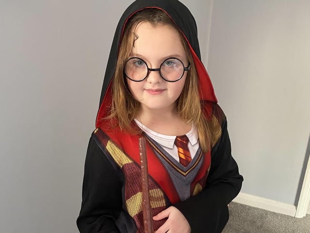 Millie casting a spell dressed as Harry Potter for World Book Day.